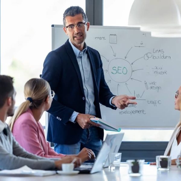 Handsome businessman explaining a project to his colleagues on coworking place